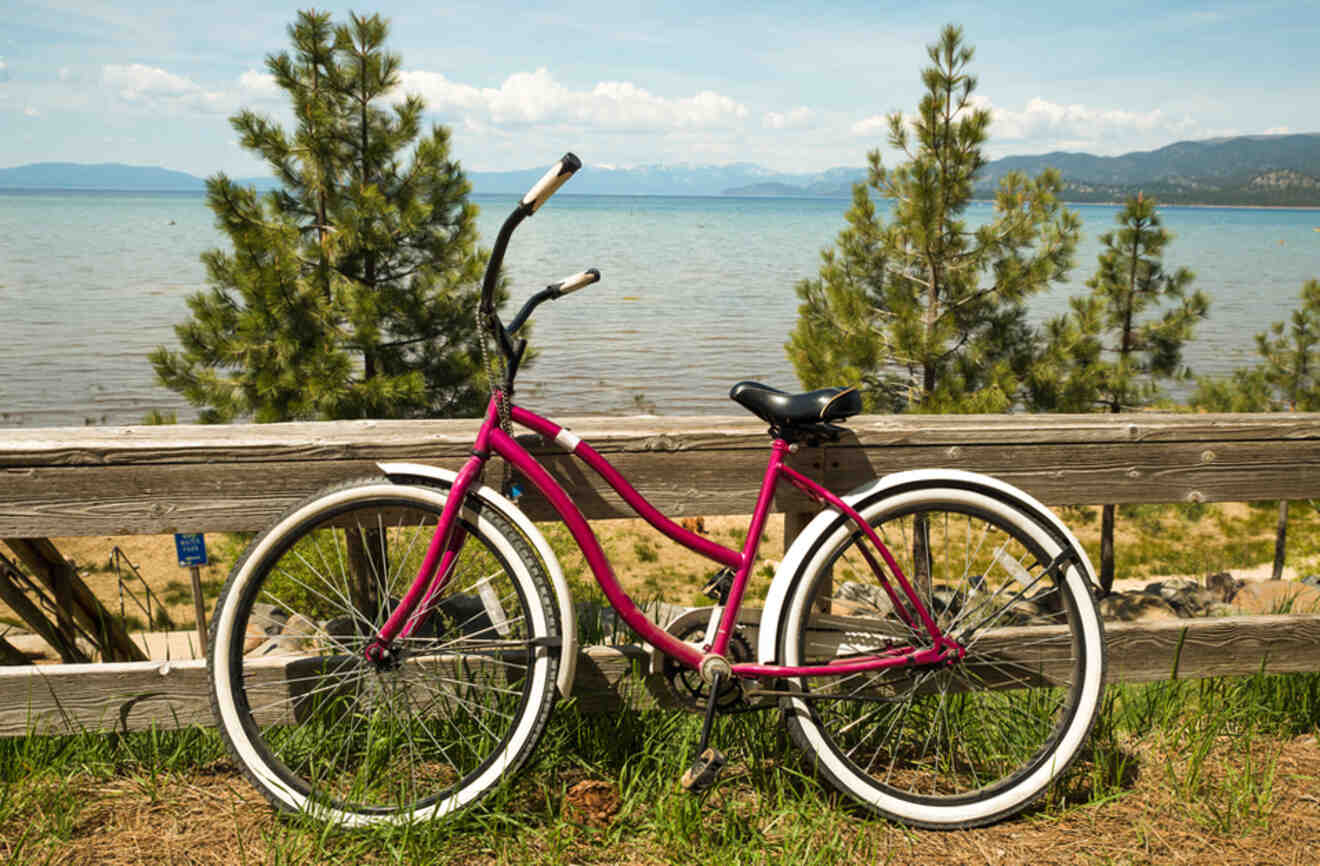 a bike leaned on a wooden railing with a lake in the backgorund