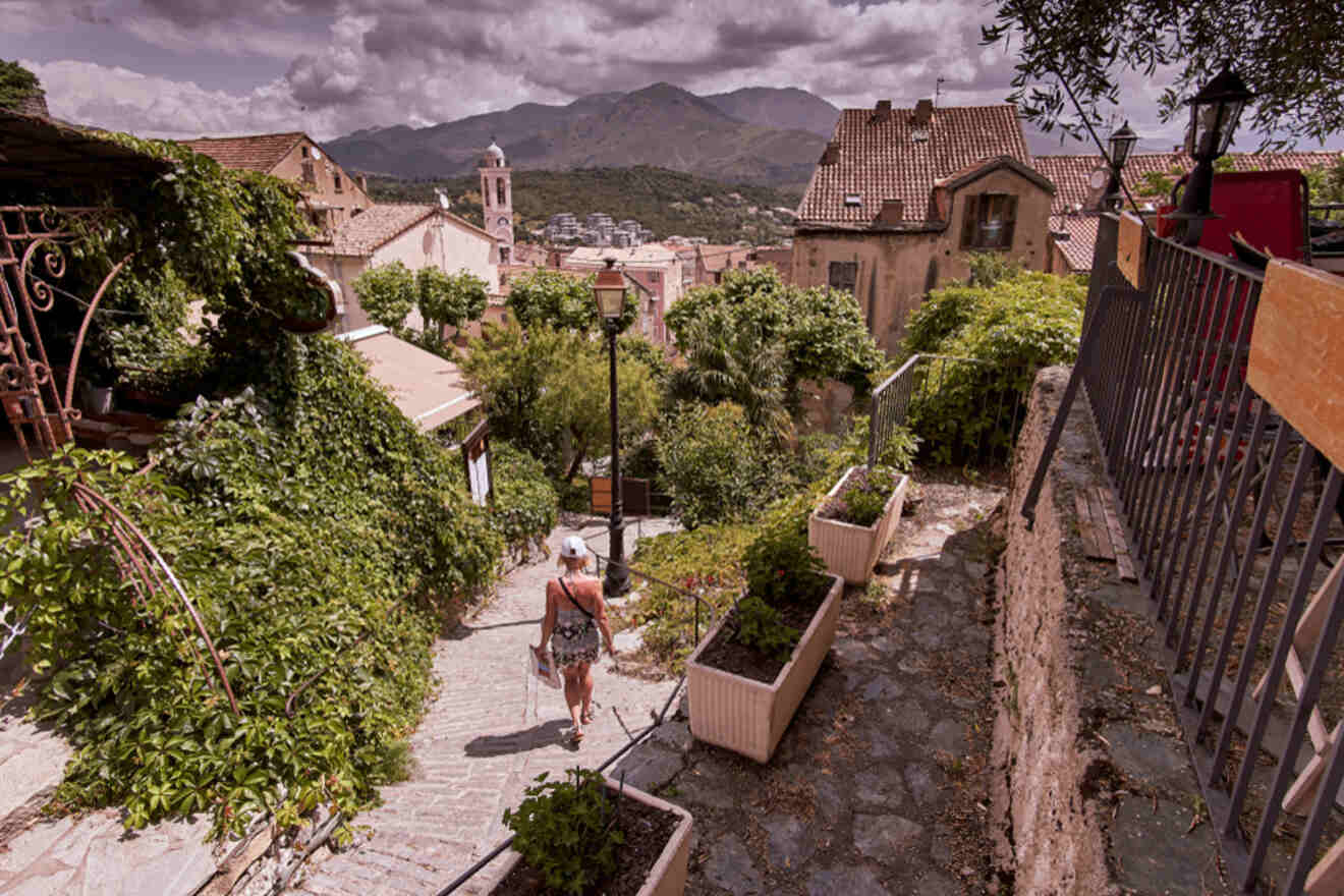 A woman is walking down a street in a small town.