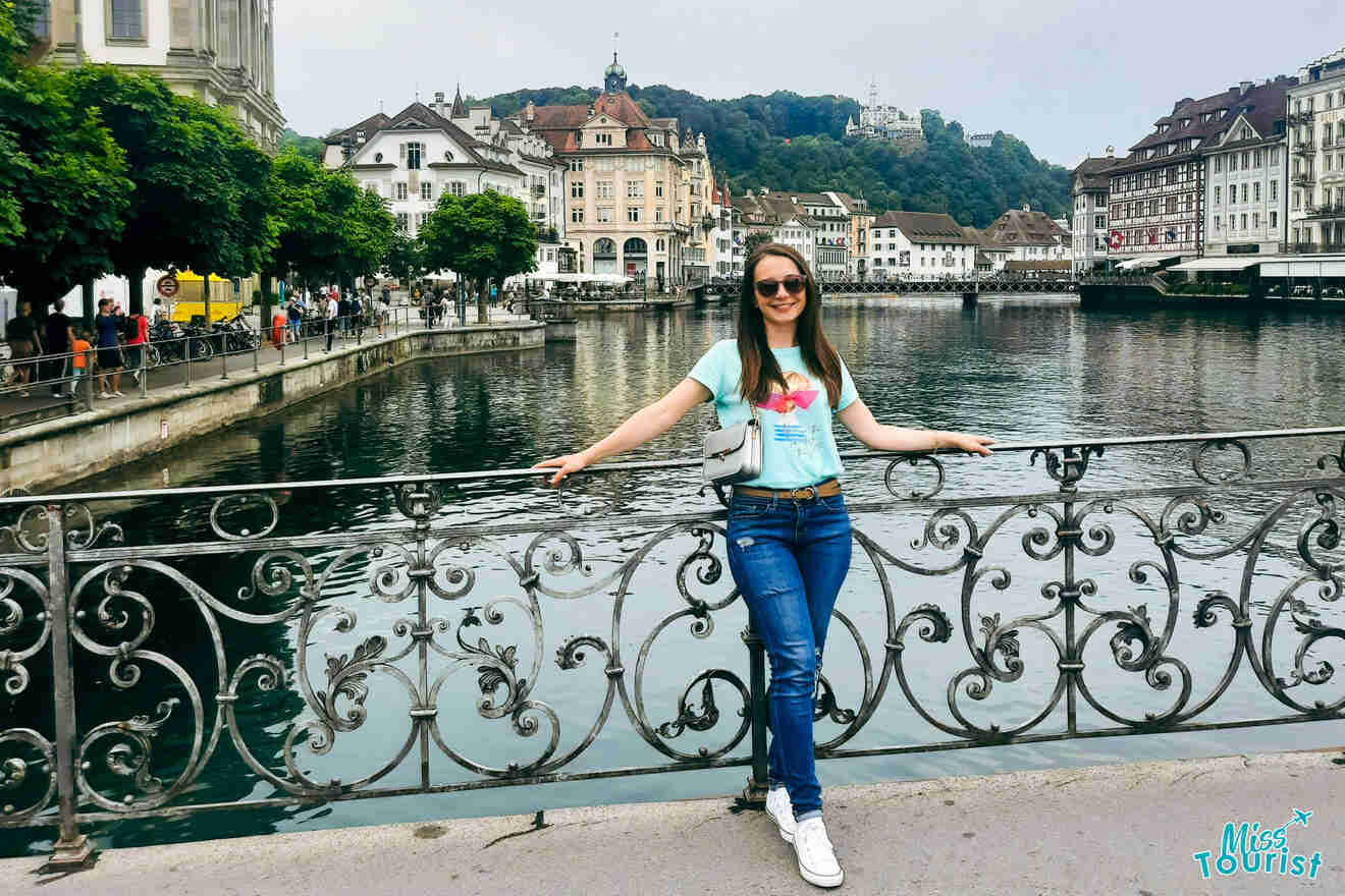 A woman standing on a bridge in a city.