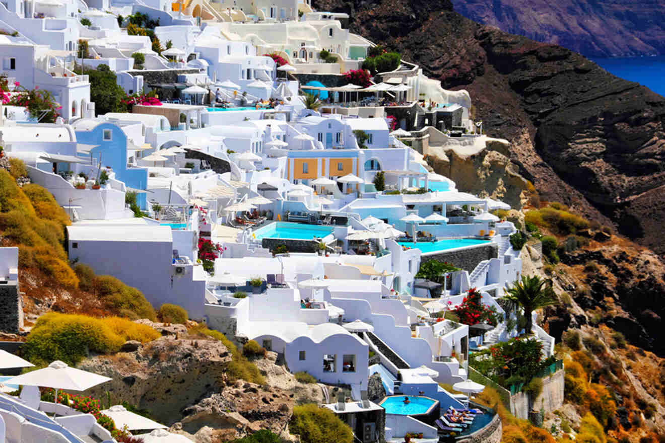 various houses and pools on a mountain in greece
