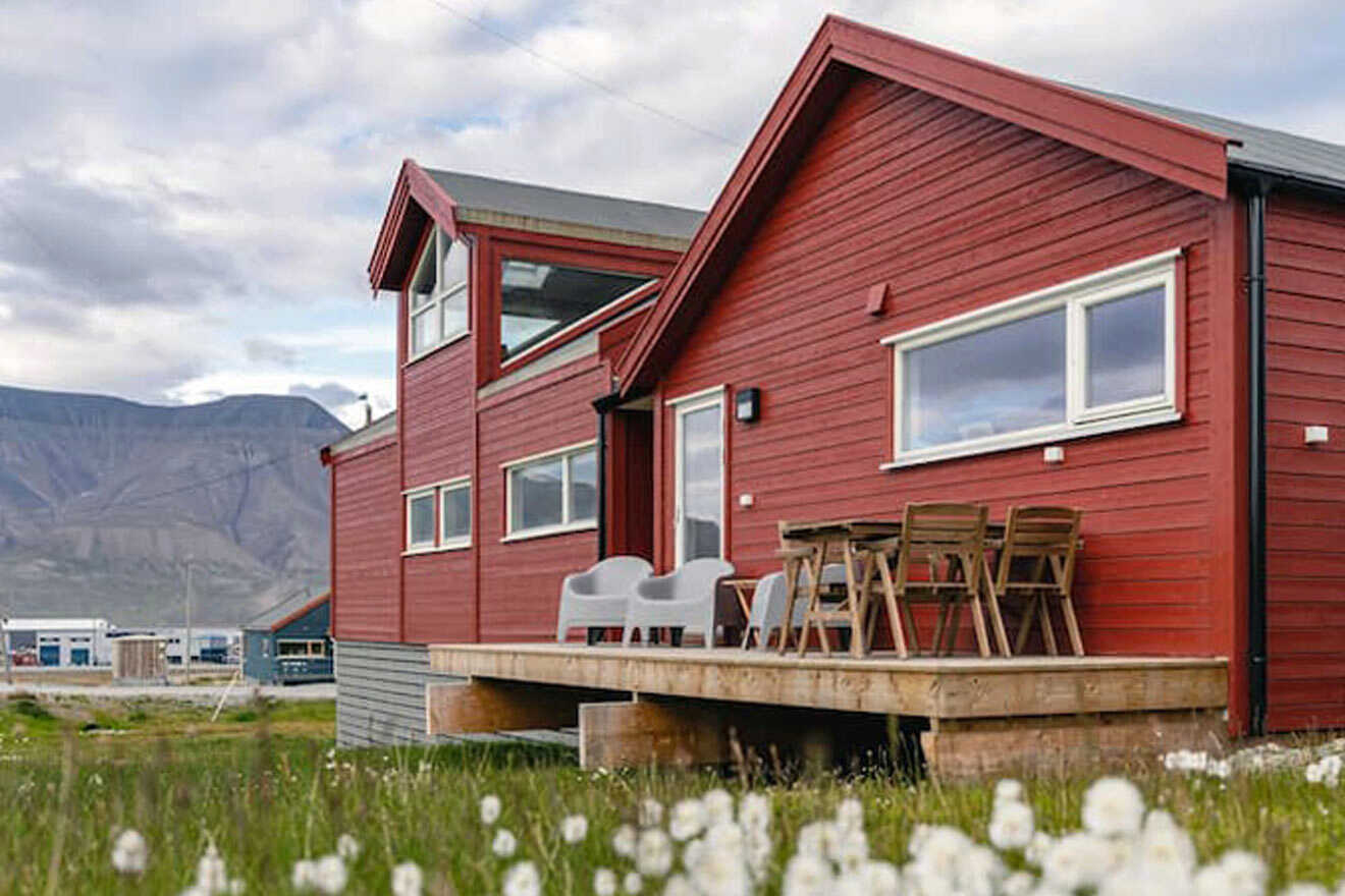 The building where a vacation home is located with chairs and tables on the porch