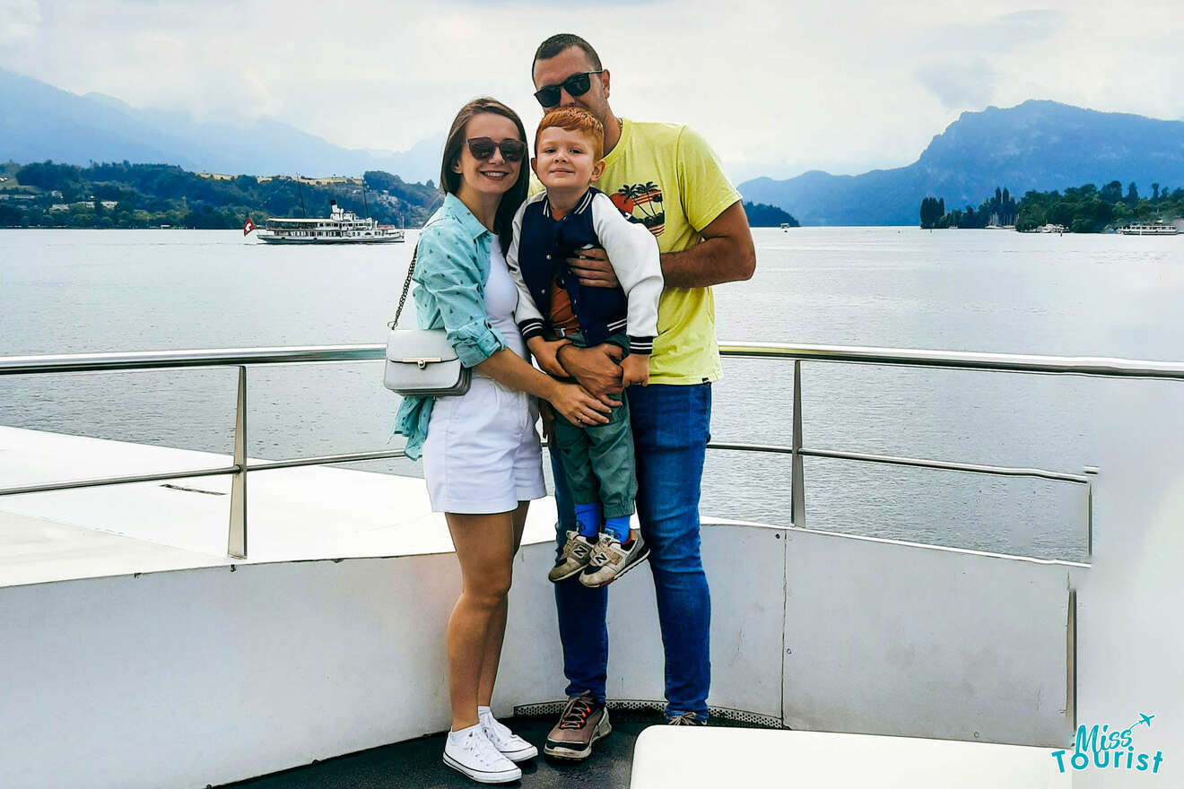 A man and woman standing on a boat with a child.