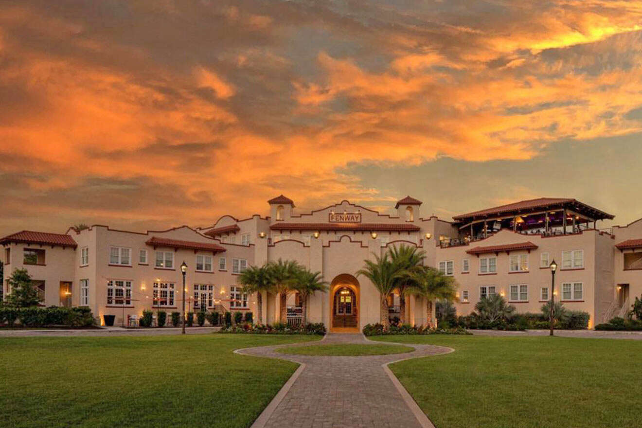A large mansion with a sunset sky behind it.