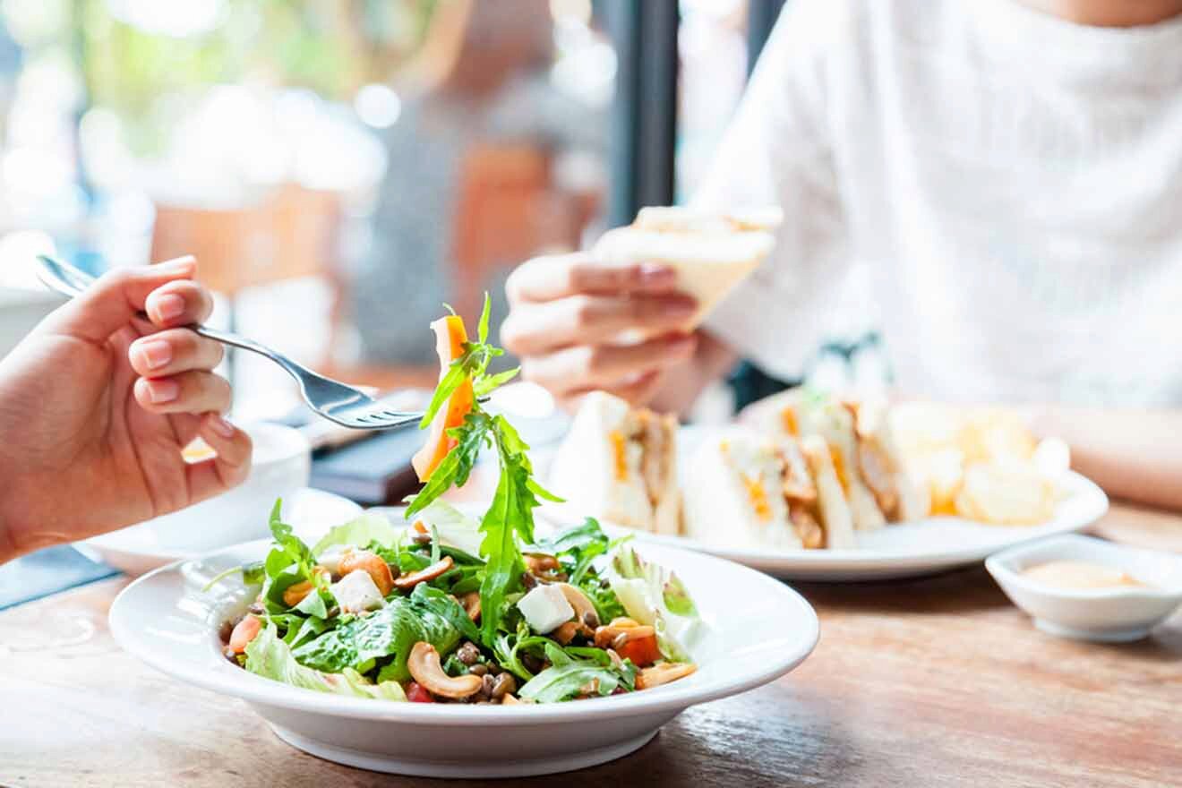 Two people eating vegan food at a restaurant.