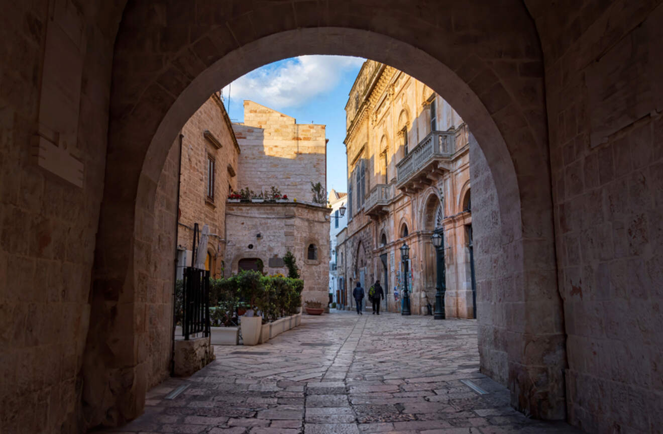 view of a city street through a stone gate