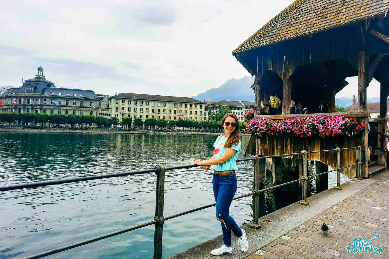 A woman standing on a wooden pier near a lake in switzerland.