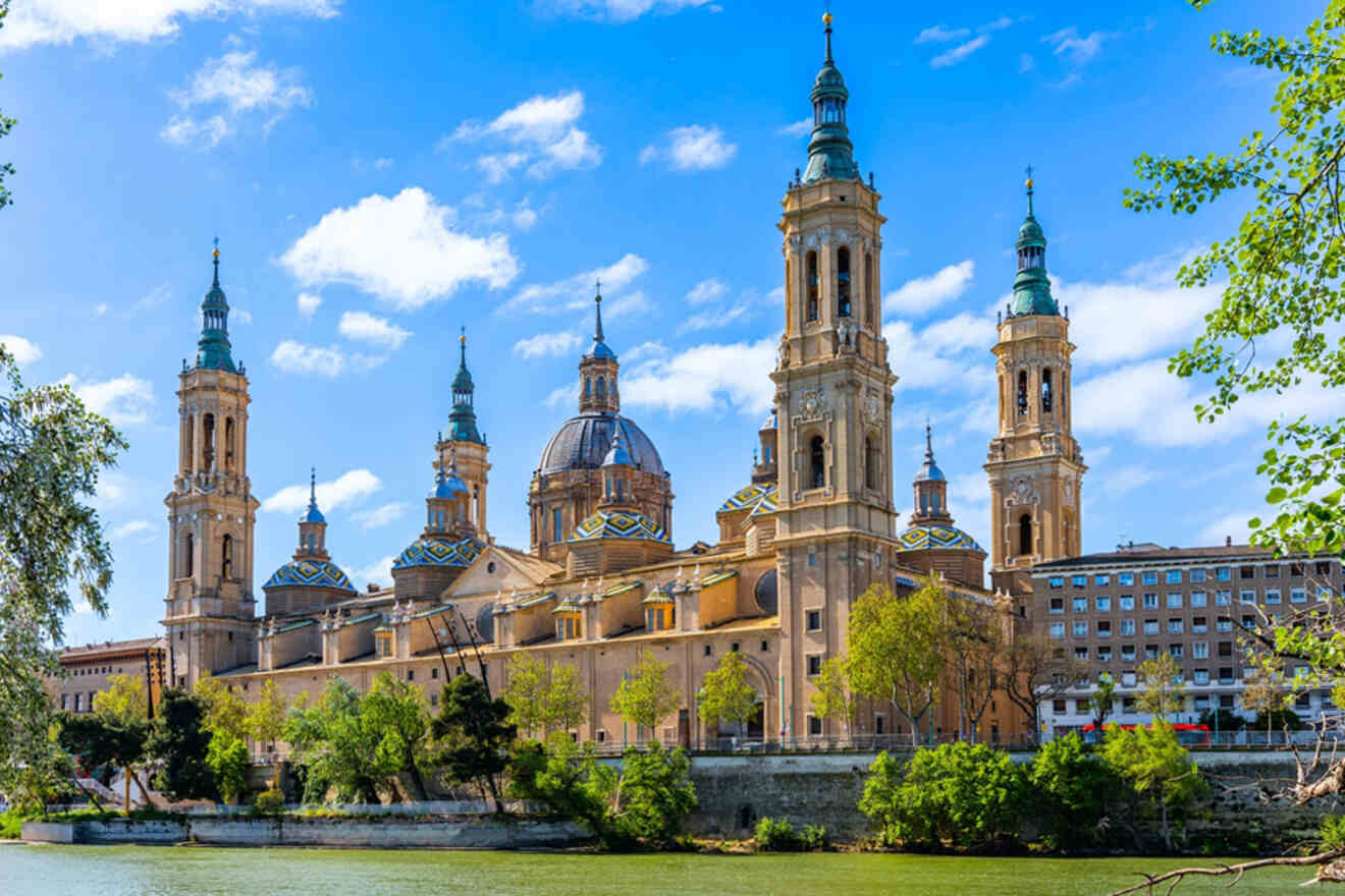 a large building with towers next to a body of water