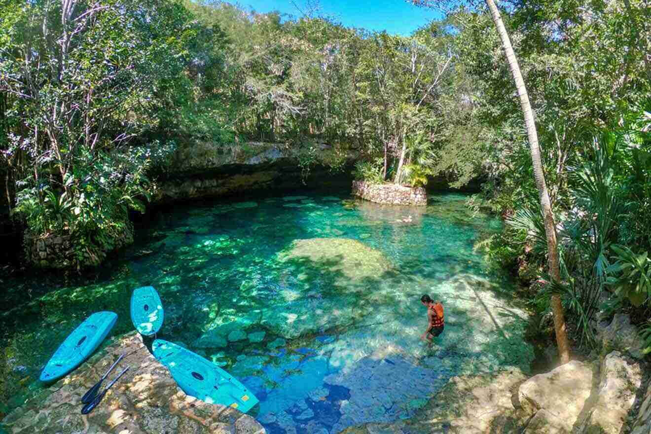A tourist in a cenote with paddling boards