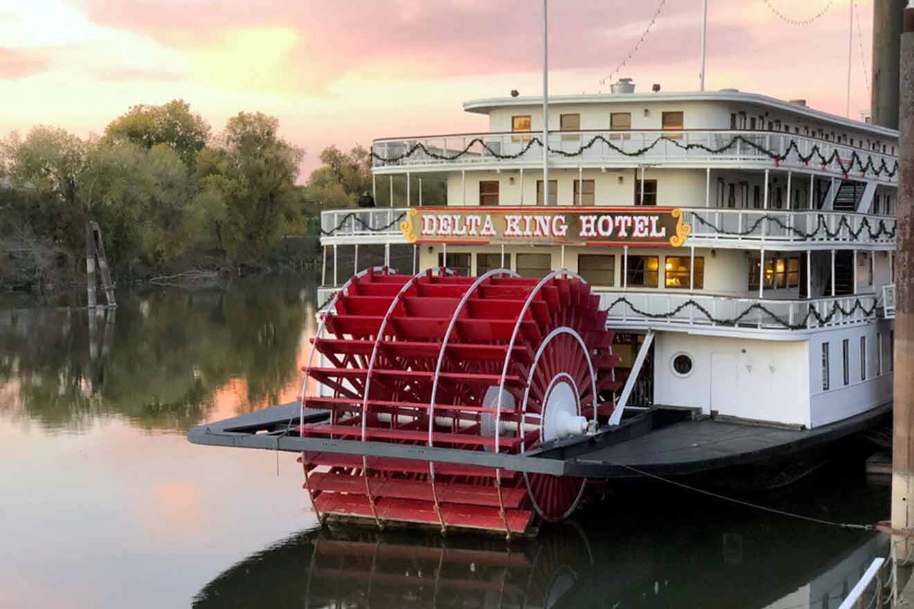 A riverboat is on a dock at sunset.