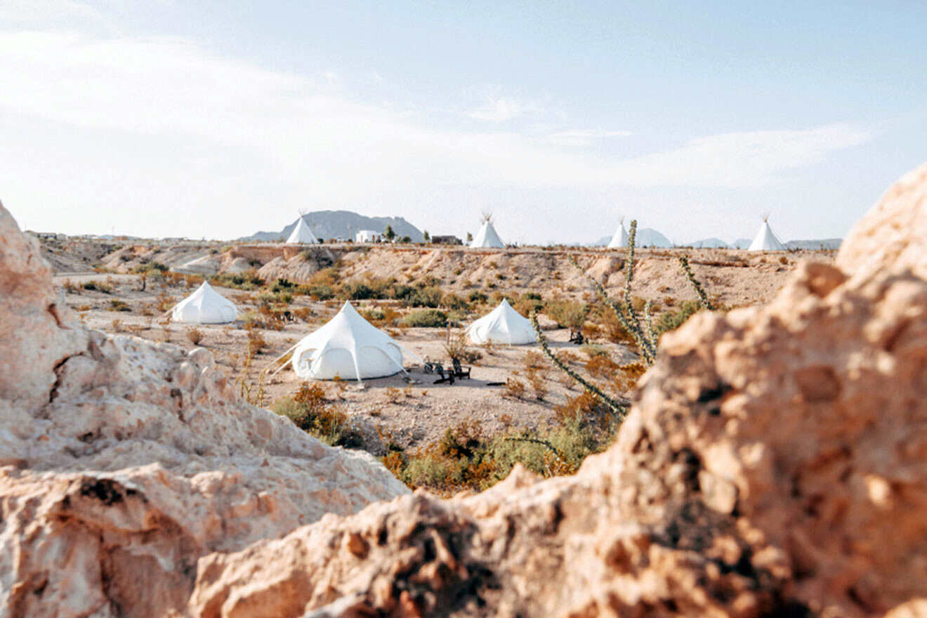 A group of white tents in the desert.