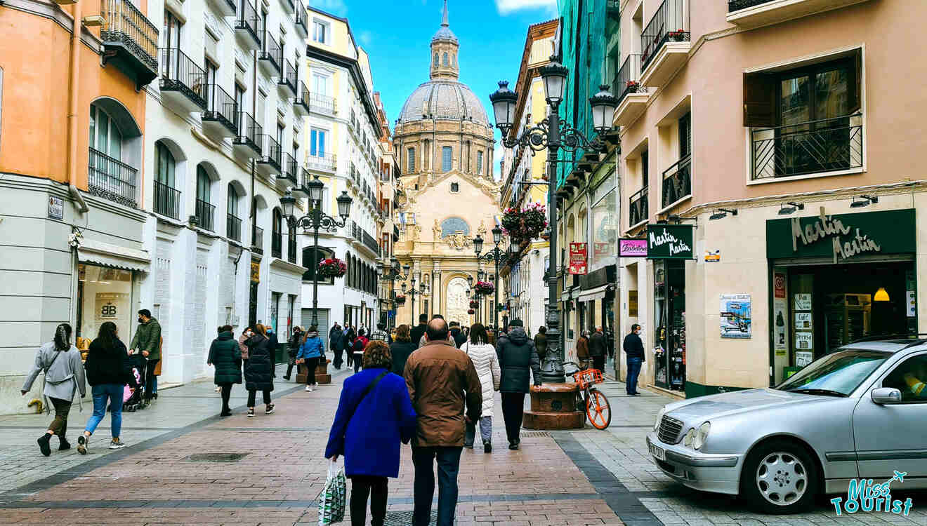 People walking down a narrow street in a city