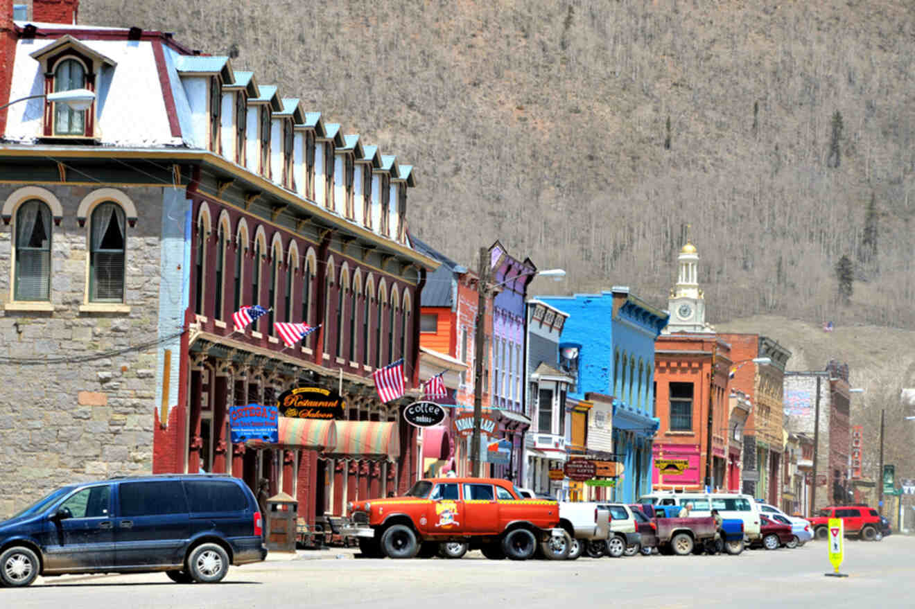 A street in a small town with a mountain in the background.