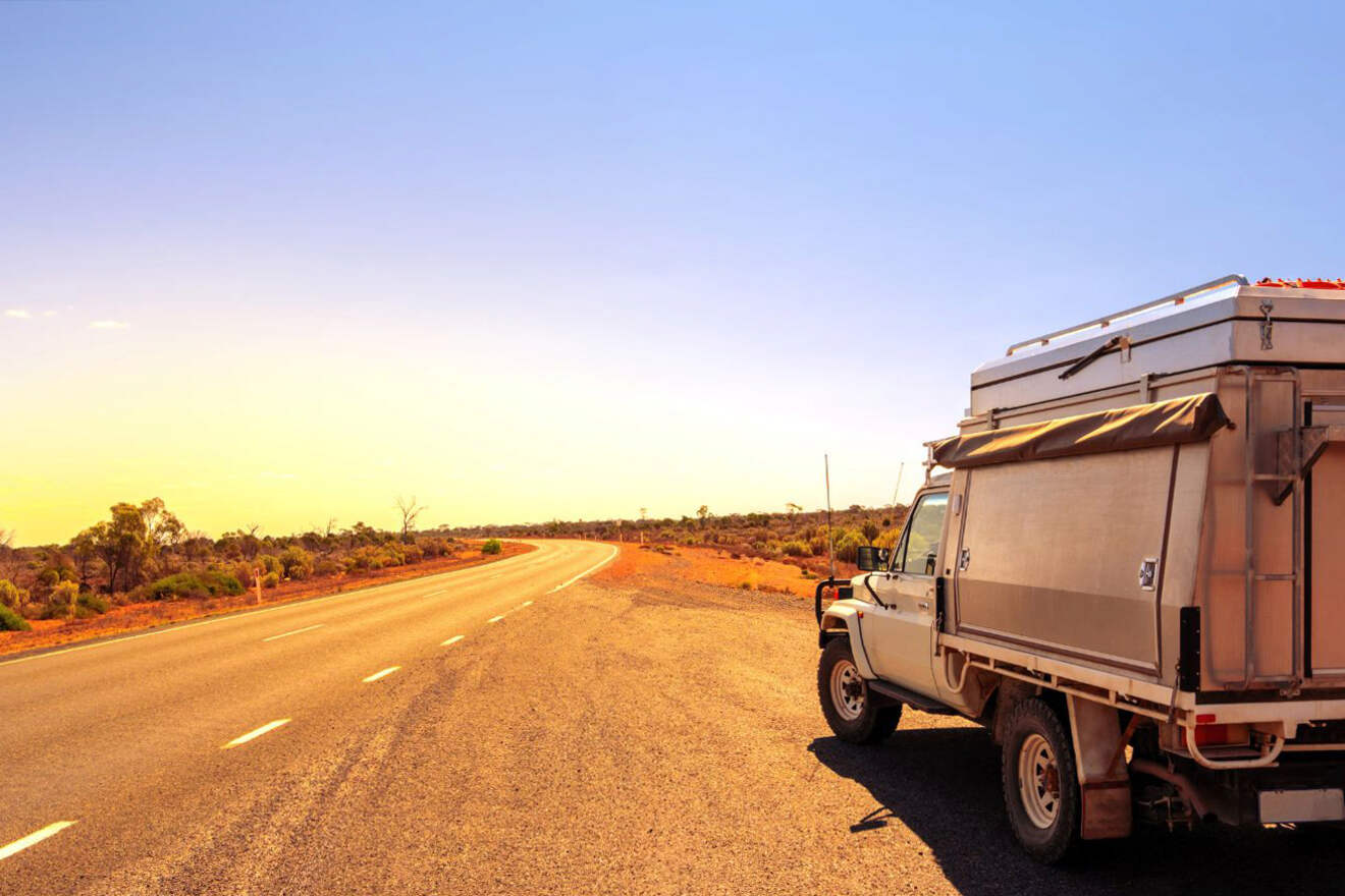 A camper van is driving down a desert road