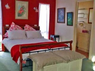 A bedroom with red walls and a bed.