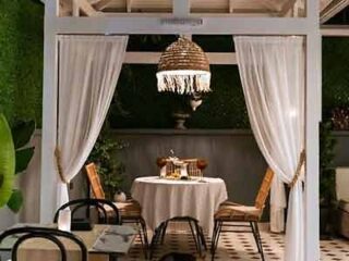 An outdoor dining area with a table and chairs.