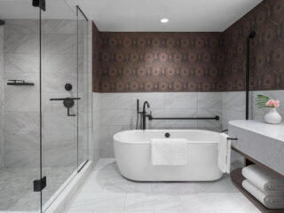 A marble bathroom with a bathtub and shower.