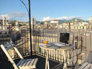 A balcony with a table and chairs and a view of the city.