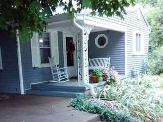 A blue house with a porch and a rocking chair.