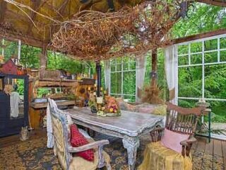 A screened in porch with a table and chairs.