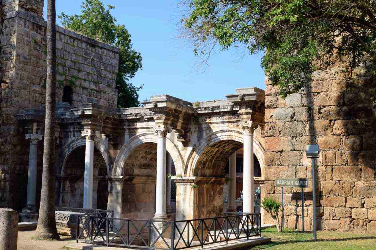 An old stone building with arches and trees.