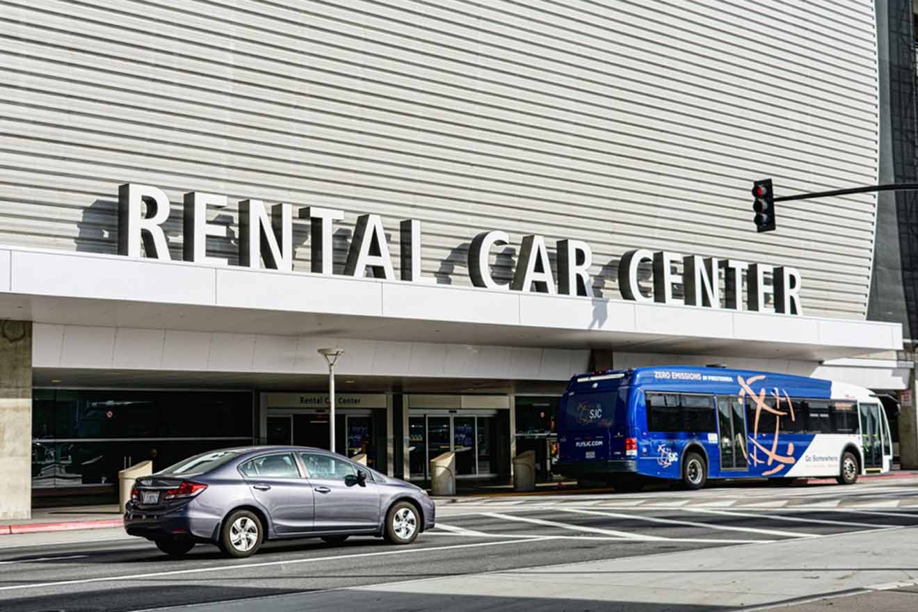 A bus is parked in front of a rental car center.