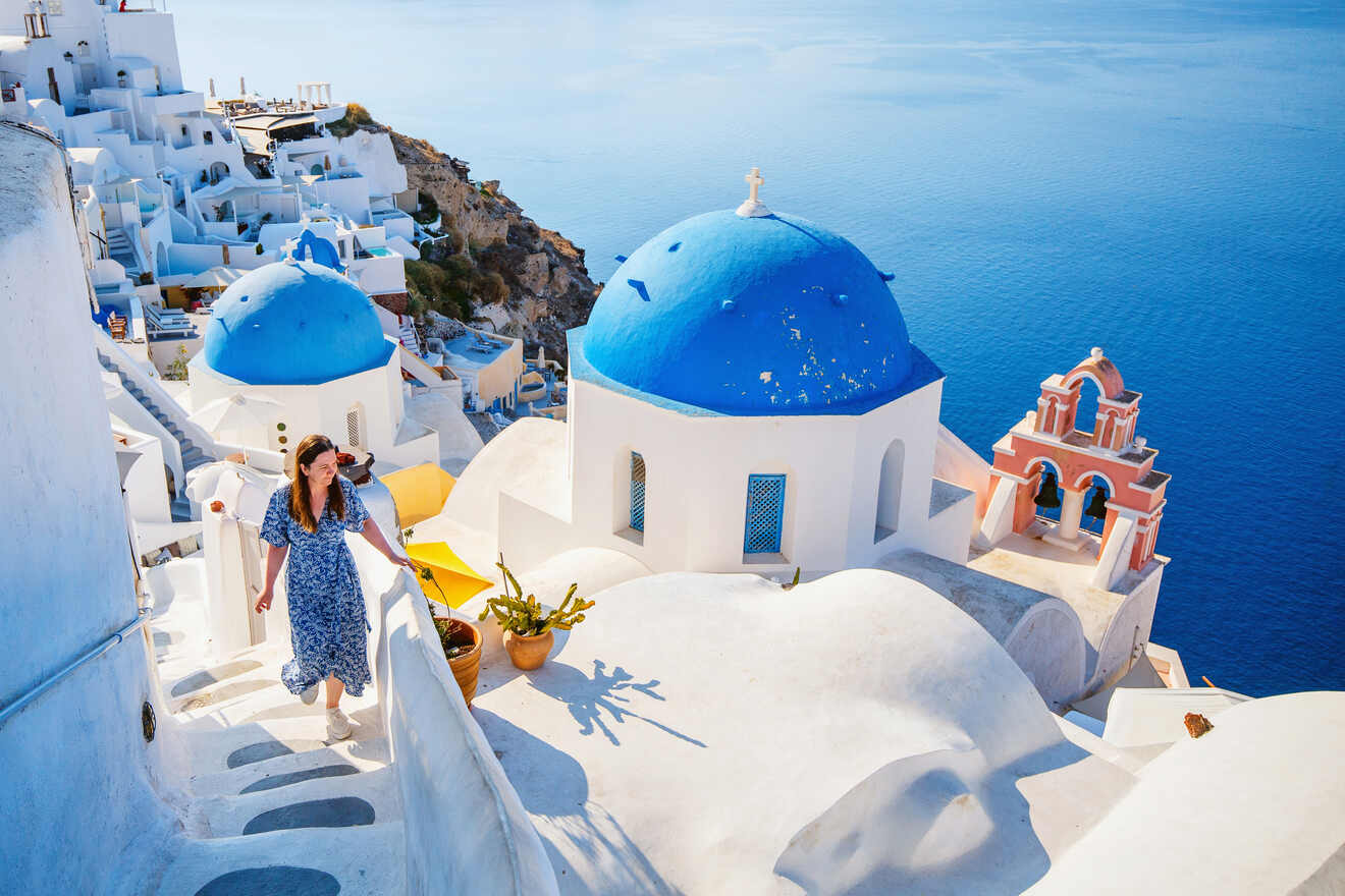 Woman climbs up the white staircase on Santorini