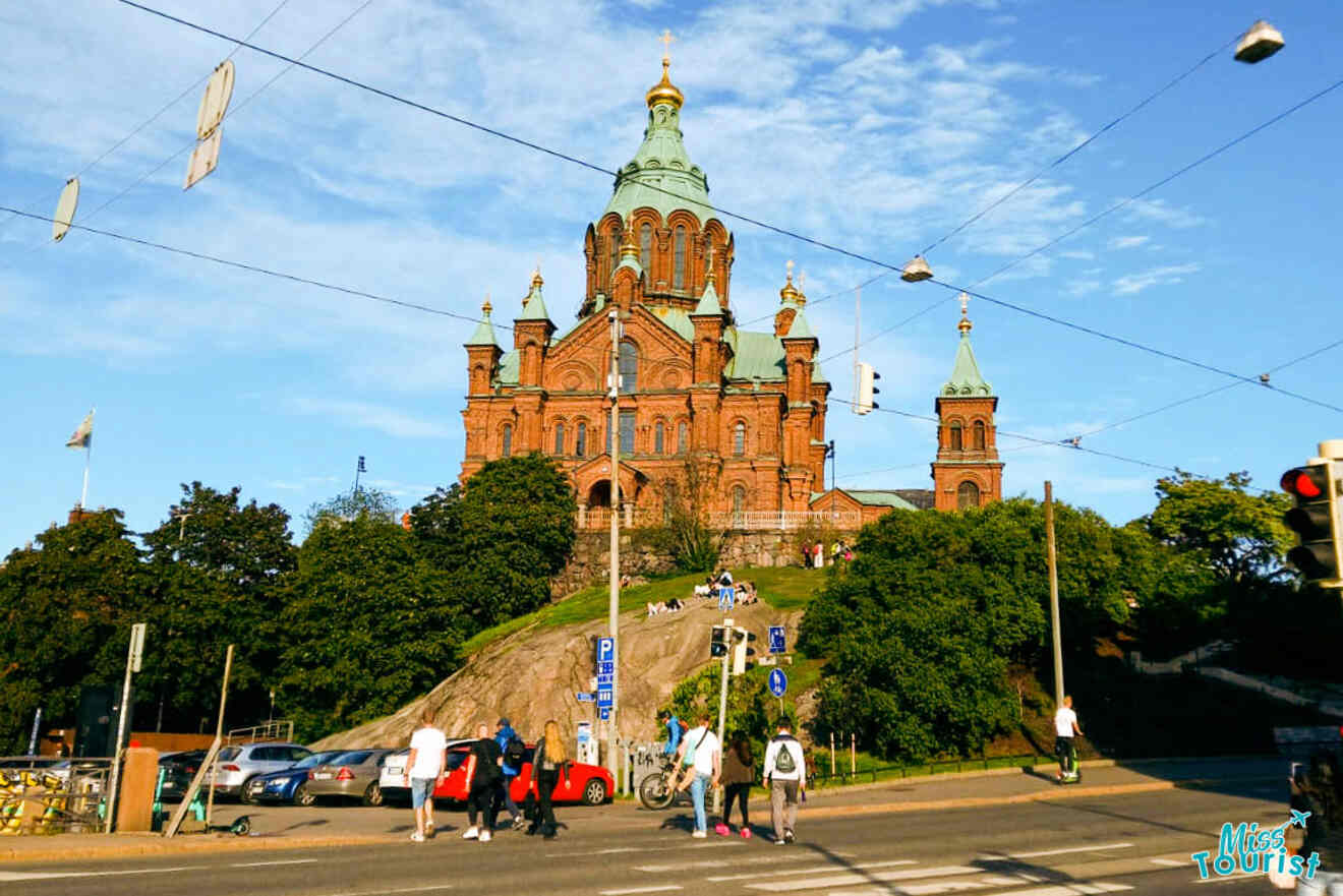 A church on top of a hill with people walking in front of it.