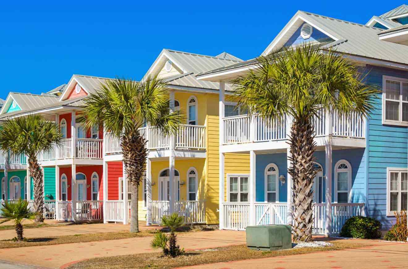 A row of colorful houses on a beach.