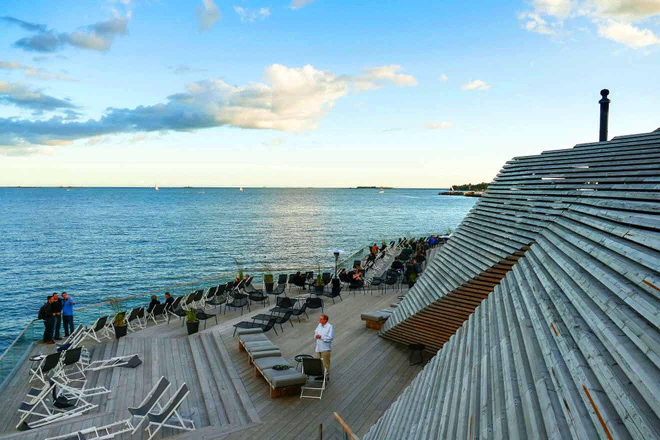 A wooden deck with chairs and a view of the ocean.