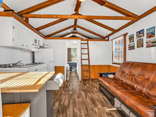 The interior of a tiny house with wooden ceilings.
