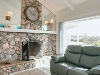 A living room with a stone fireplace.