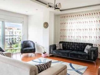 A living room with a balcony overlooking a city.