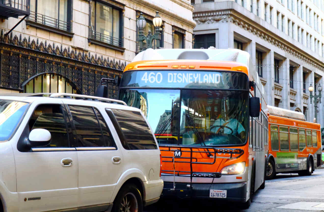 a bus going to Disneyland between cars on a street