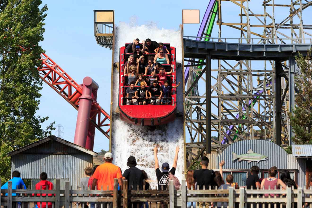A group of people riding a roller coaster at an amusement park.