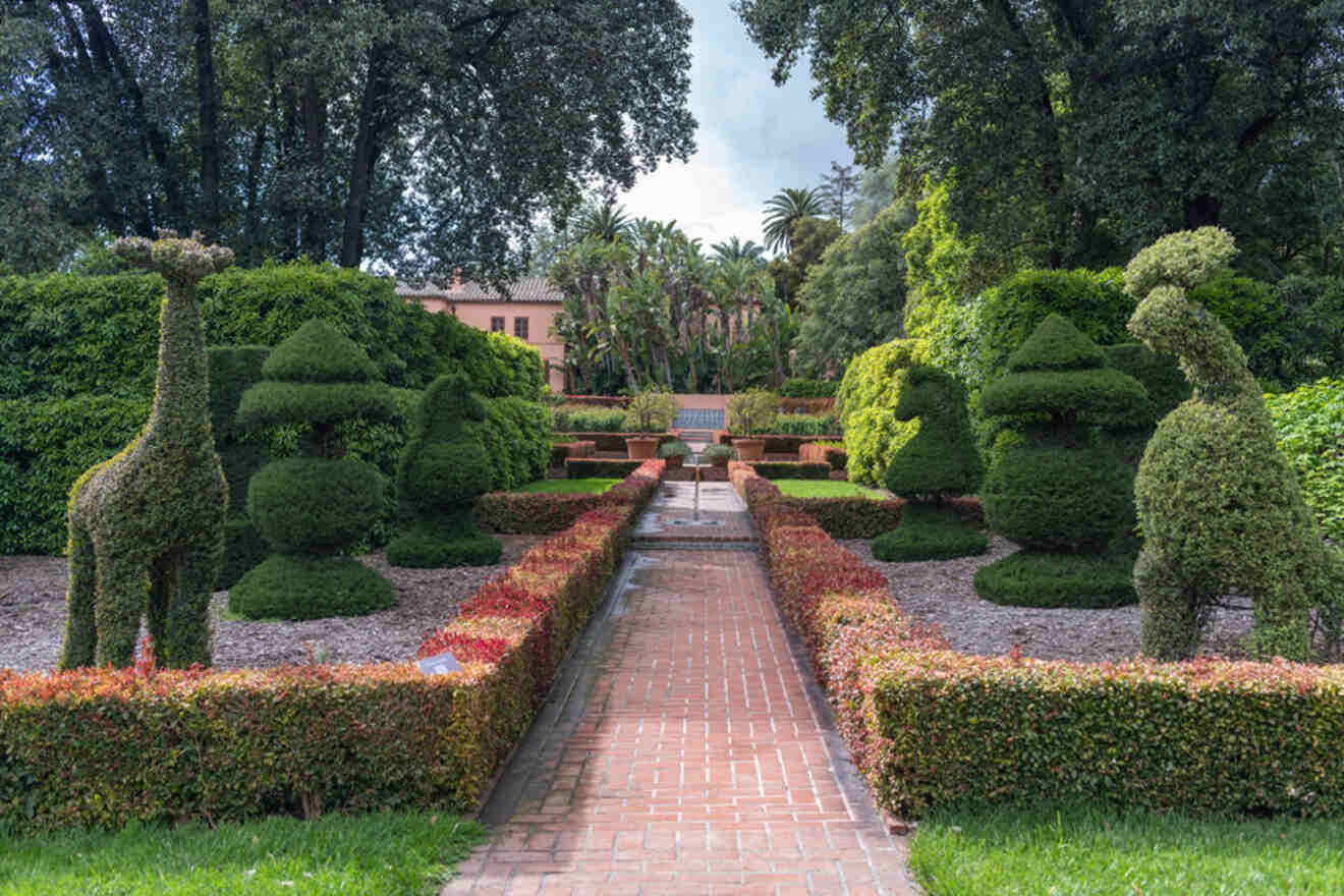 A garden with topiary and giraffe statues.