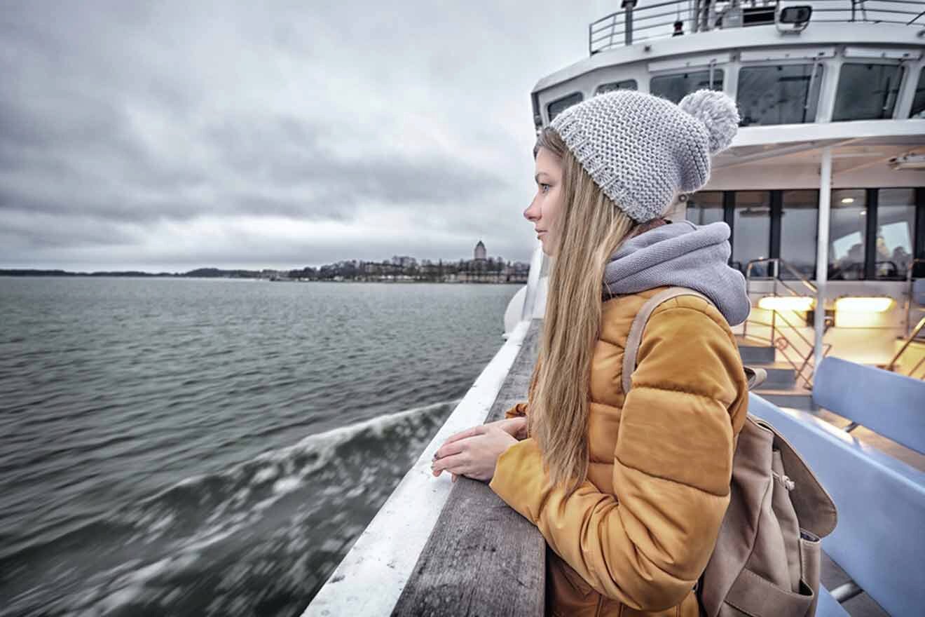 A woman looking out of a ferry on a cloudy day.