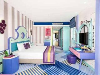 A colorful room with a bed and a desk.