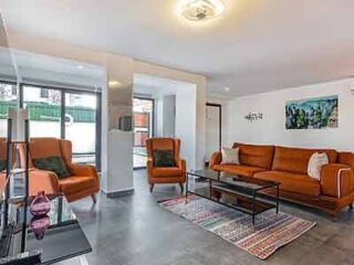 A living room with orange couches and a television.