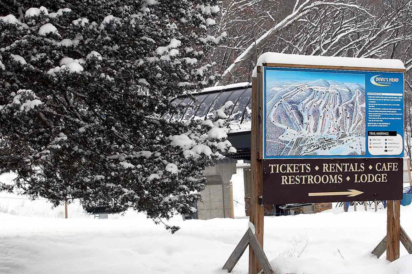 A sign for a ski resort in the snow.