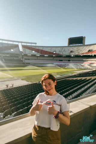a girl giving thumbs up from football stands