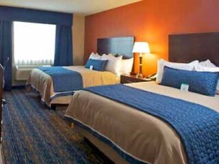 Two beds in a hotel room with blue and orange accents.