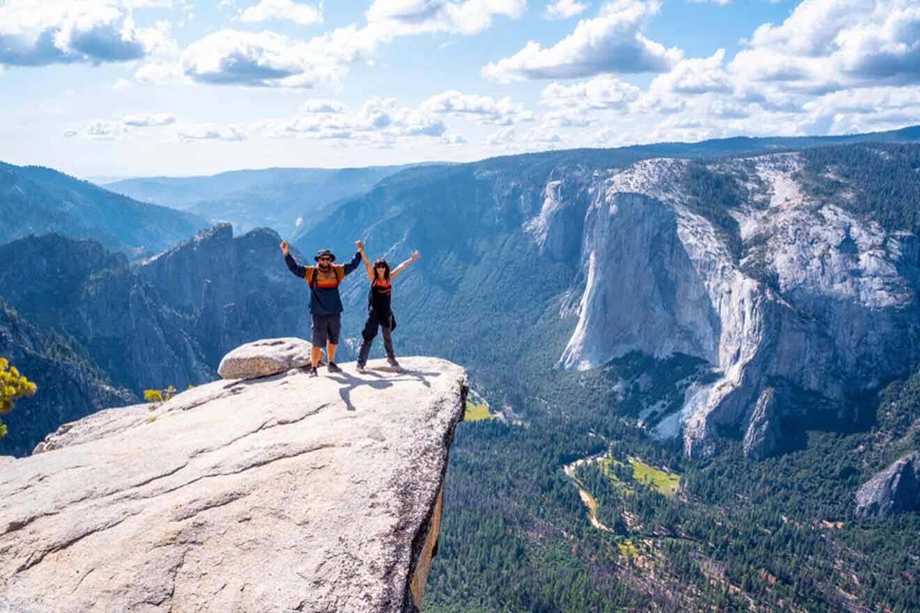 Two people standing on top of a cliff in yosemite national park.