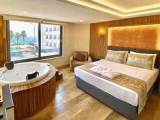 A hotel room with a large bed and a jacuzzi tub.