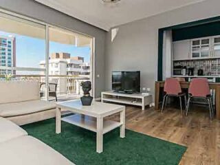 A living room with a balcony and a view of the city.