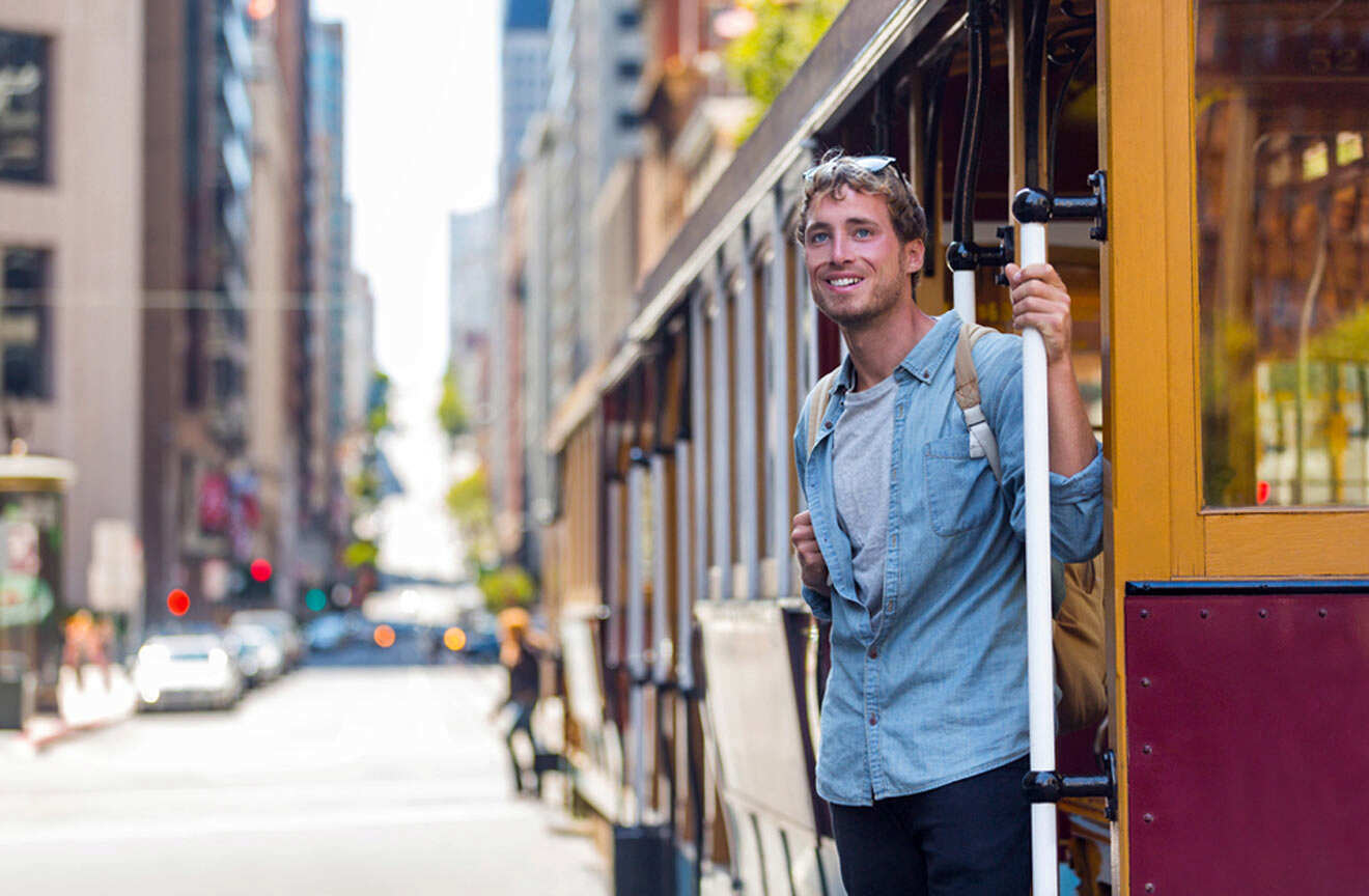 A man is standing on a trolley car in san francisco.