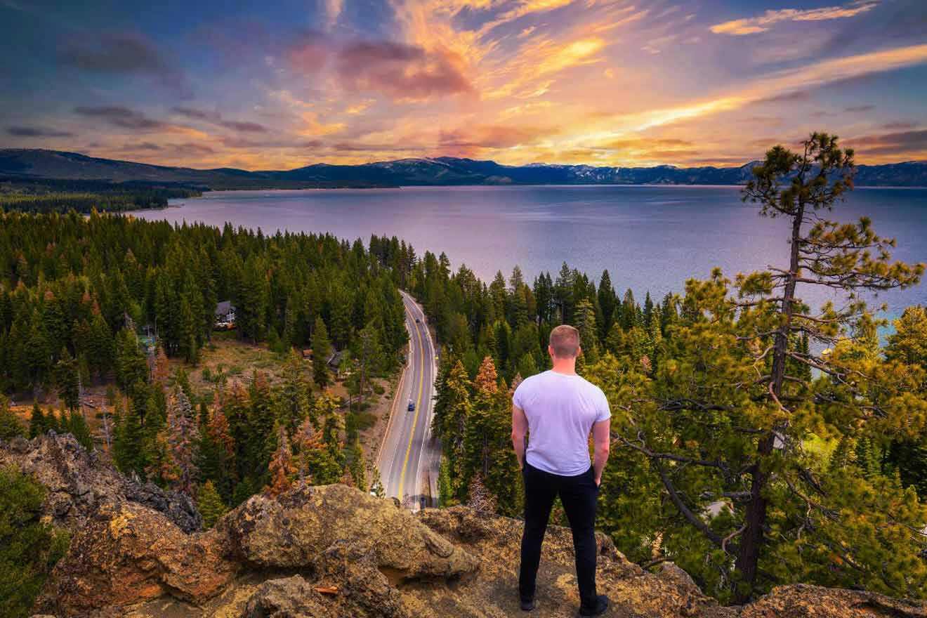 A man standing on top of a mountain overlooking lake tahoe.