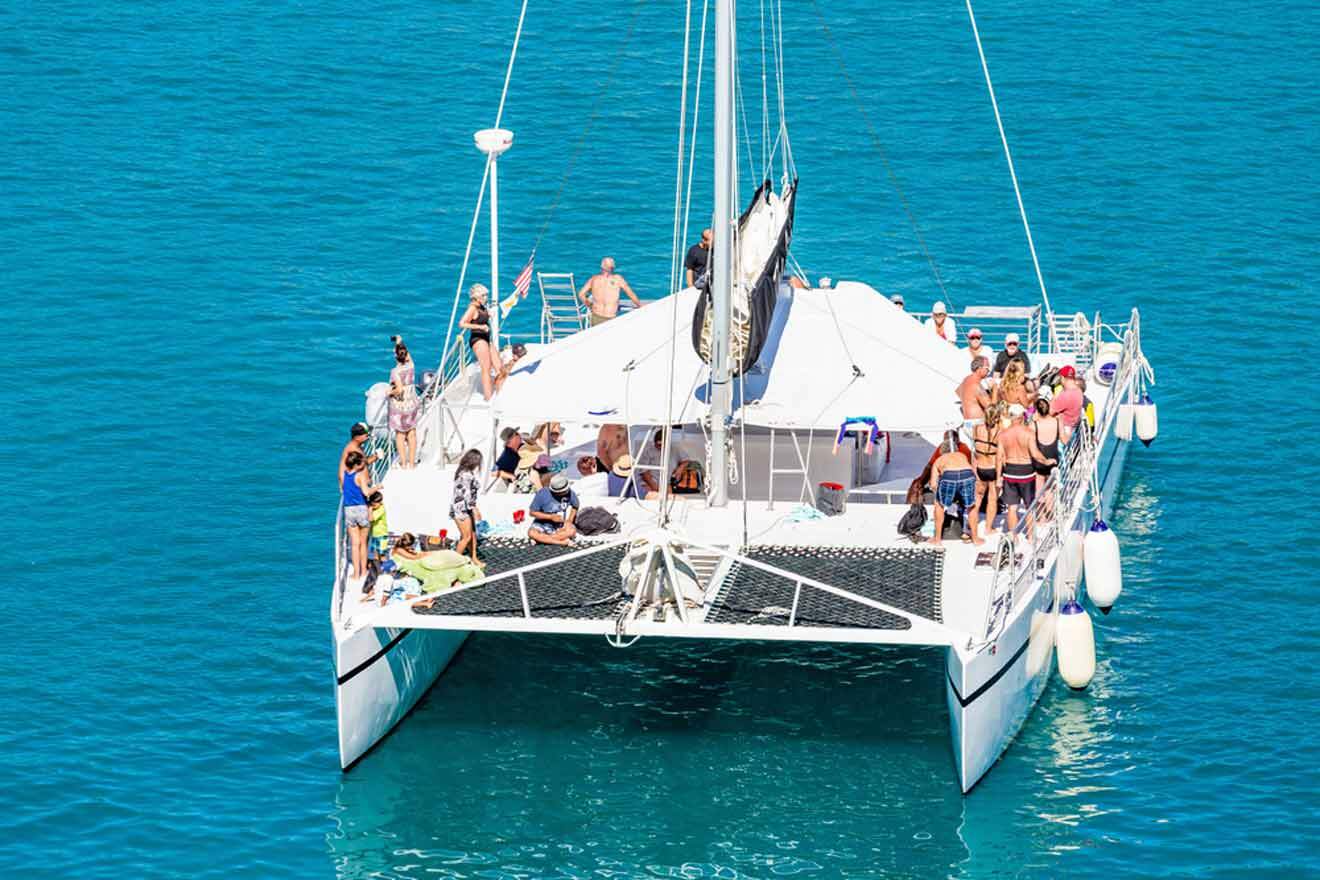 A group of people on a white catamaran in the ocean.