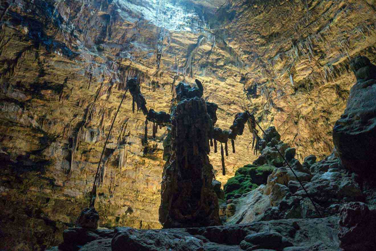 A statue is standing in the middle of a cave.