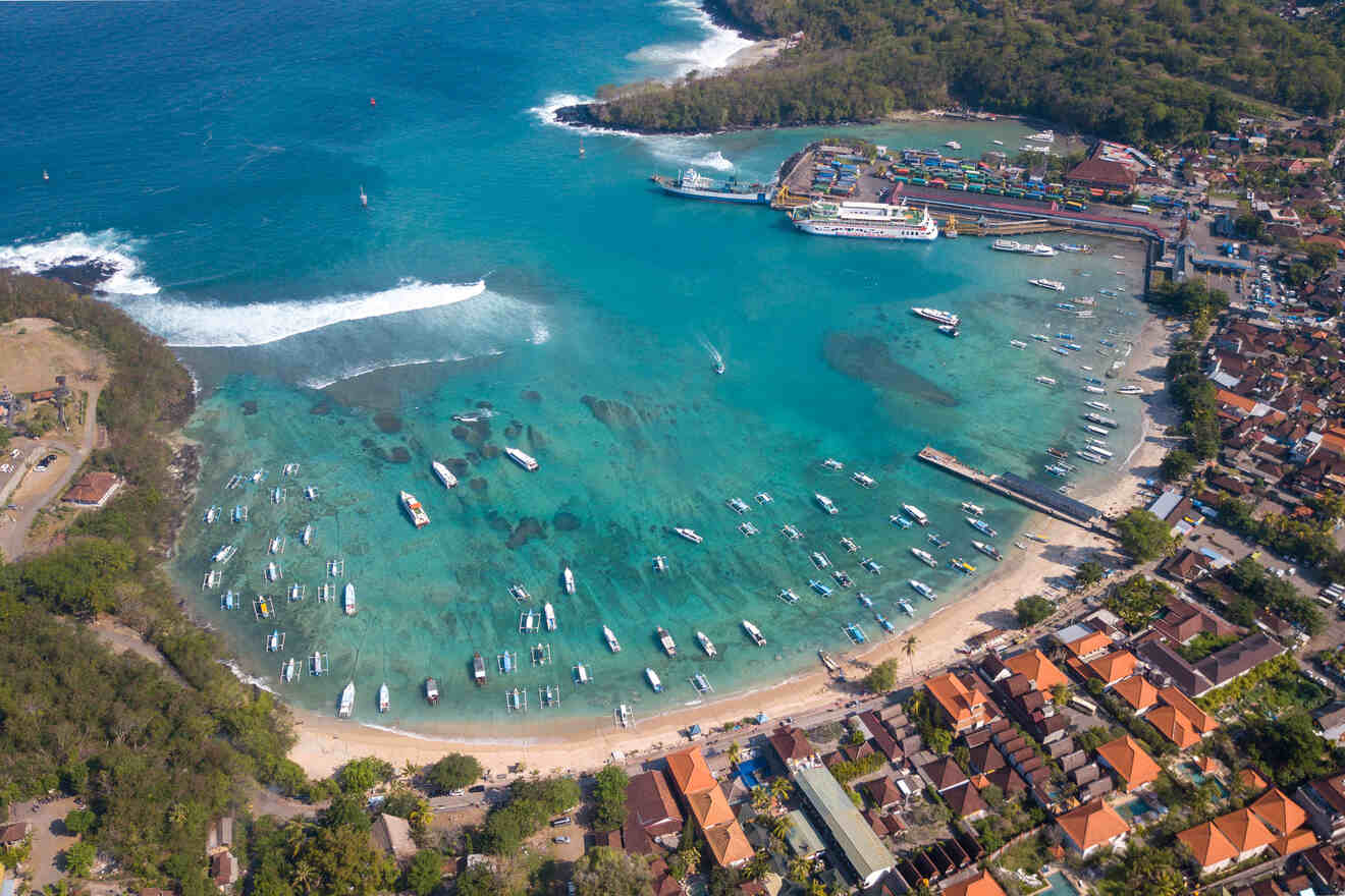 An aerial view of a beach with boats docked in the water.