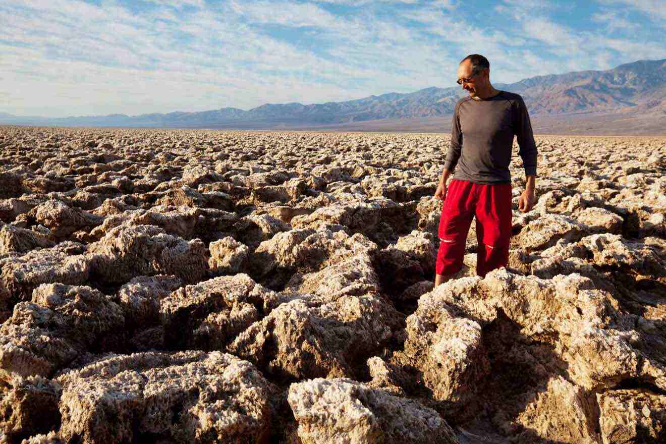 A man standing in the middle of a field of rocks.
